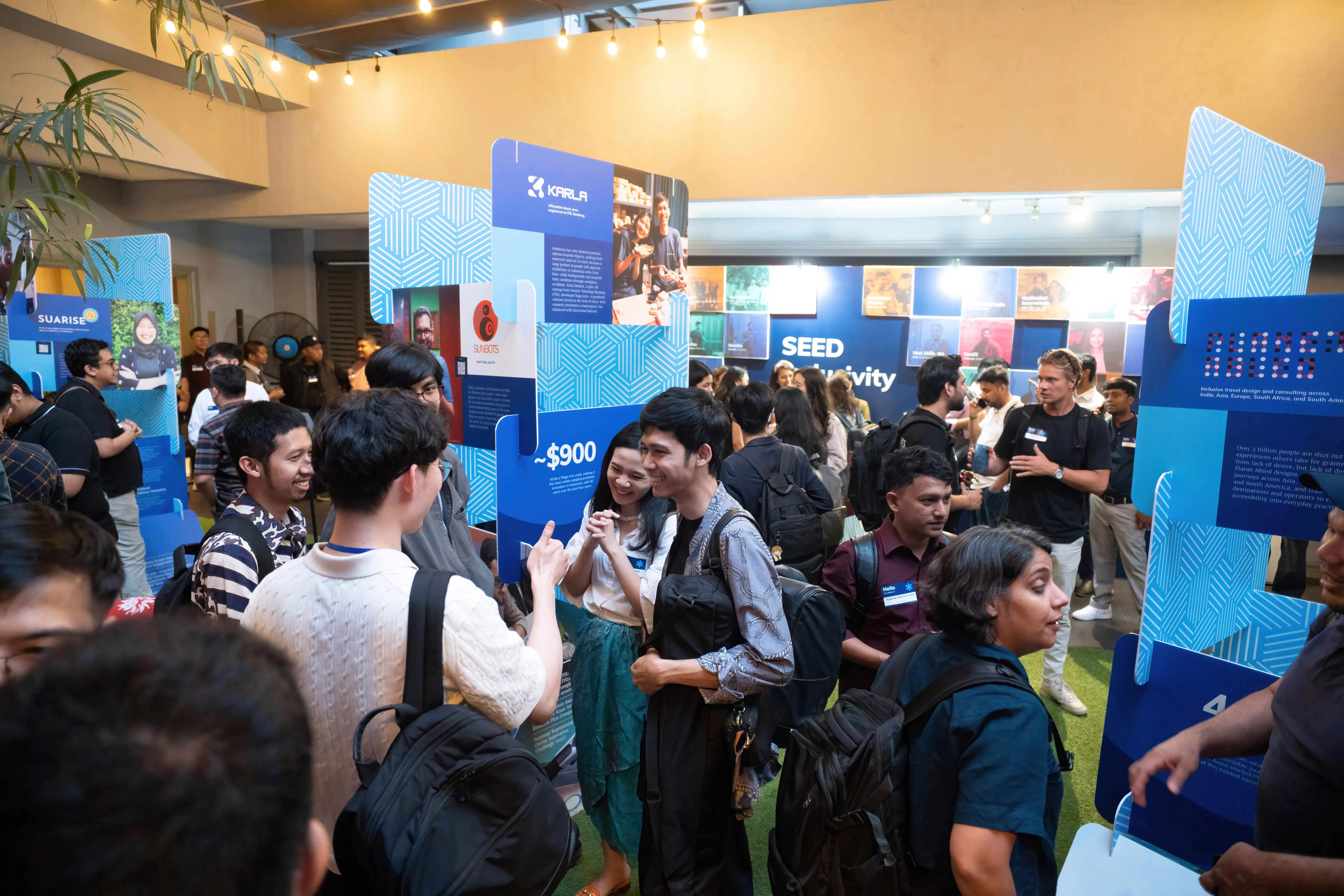 Visitors exploring the SEED Inclusivity gallery exhibition in Jakarta, venture panels lining the walls